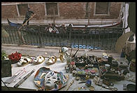 Two Venetian icons in one picture. Foreground: carnival masks in a shop. Background: gondolier.